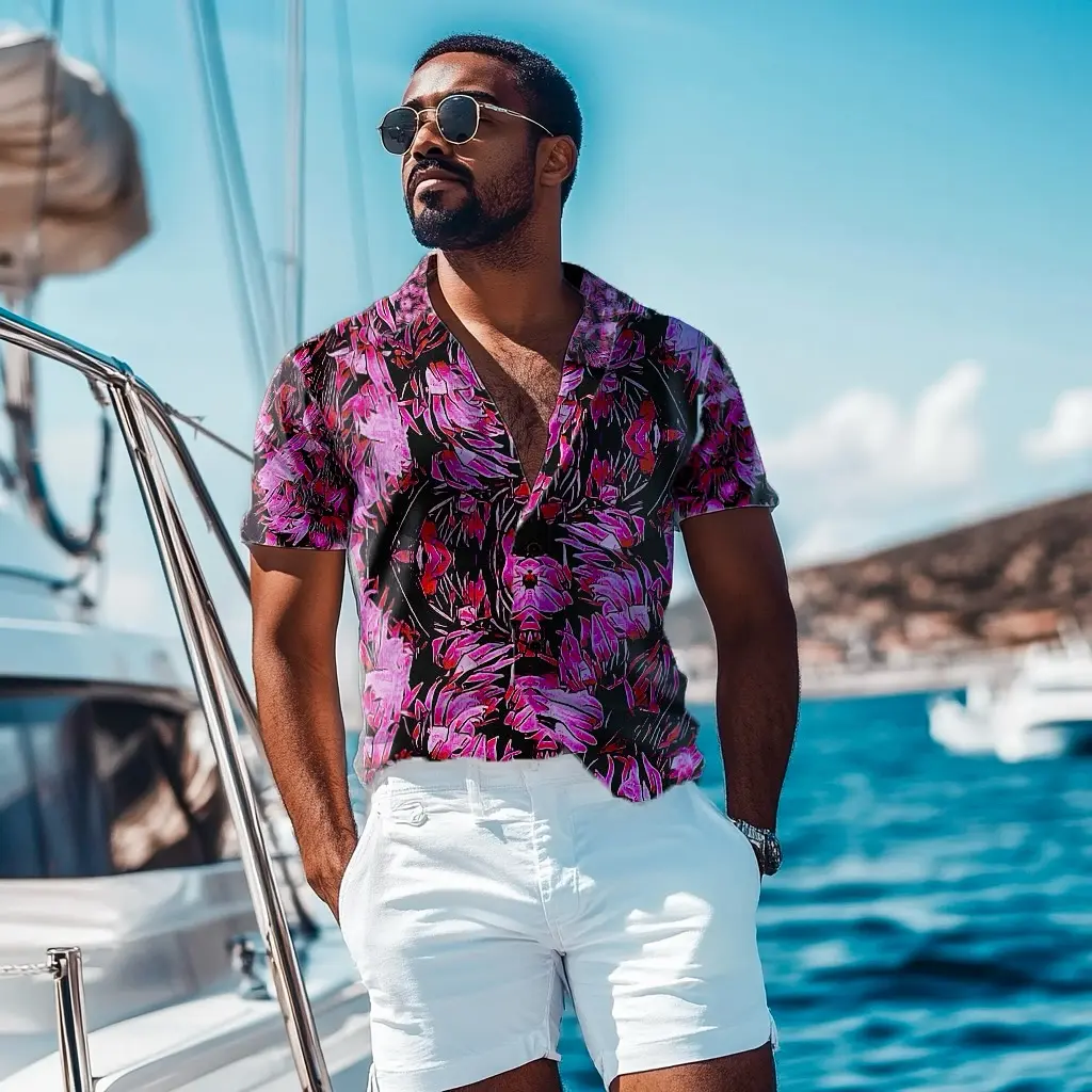 A man wearing a colorful Bula shirt beside the water