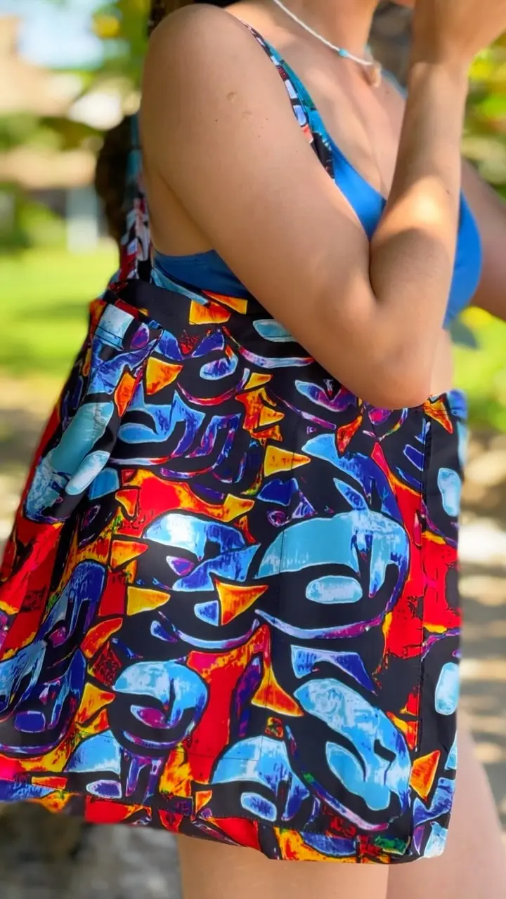 A woman carrying a colorful patterned tote outdoors